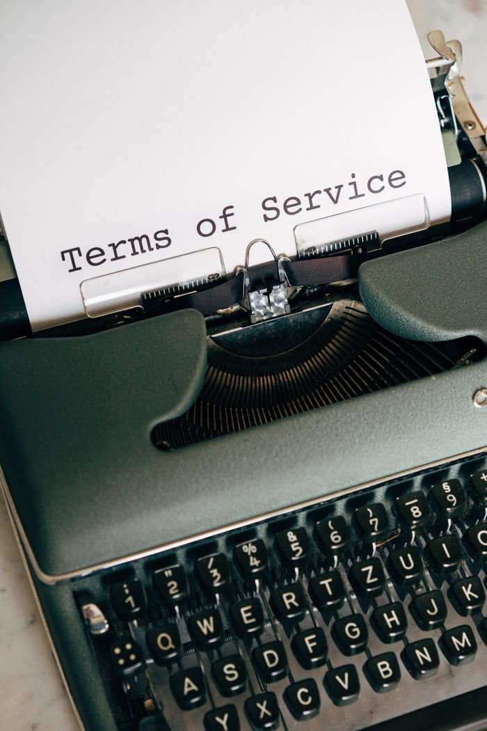 Services Close-up of a vintage typewriter typing 'Terms of Service' on paper.