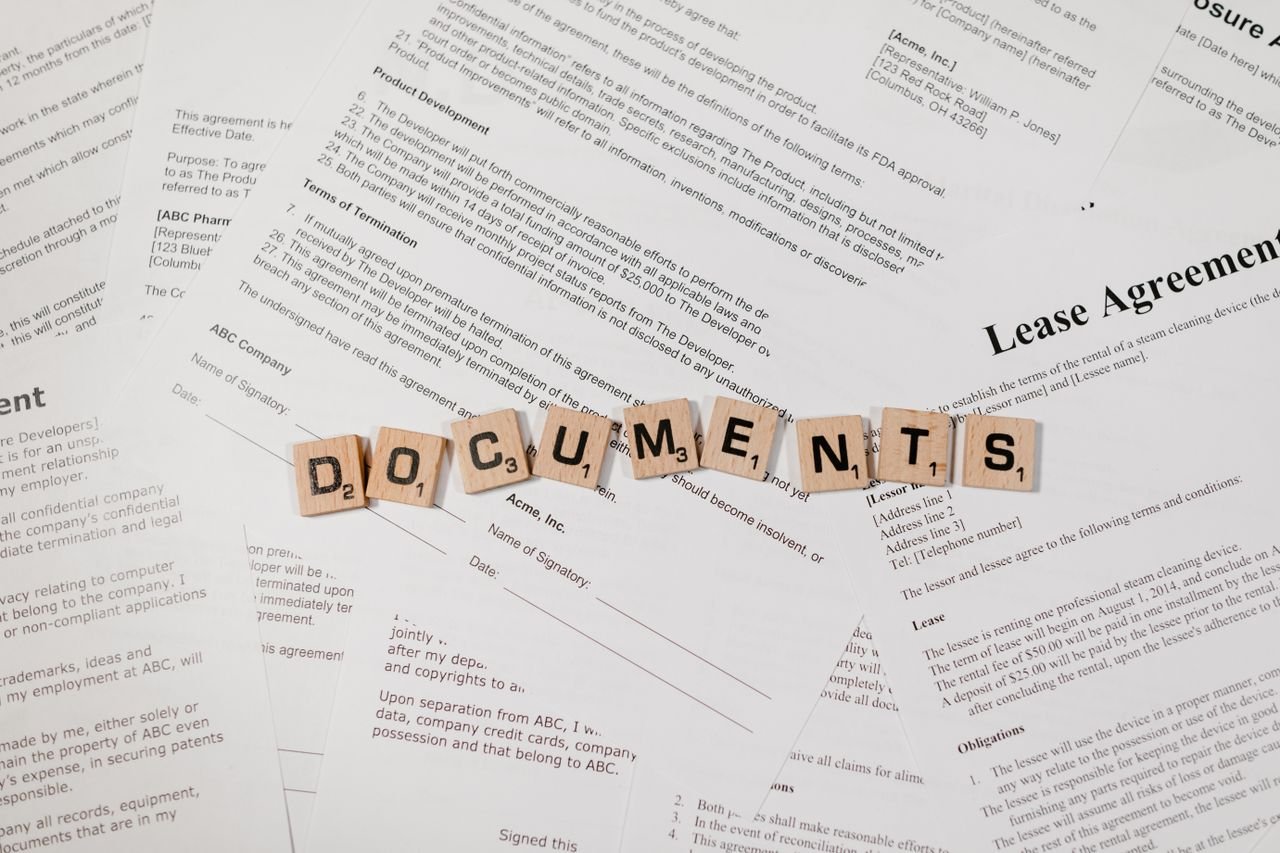 Crafting Captivating Headlines: Your awesome post title goes here Top view of scrabble tiles spelling 'DOCUMENTS' on various contracts and agreements.